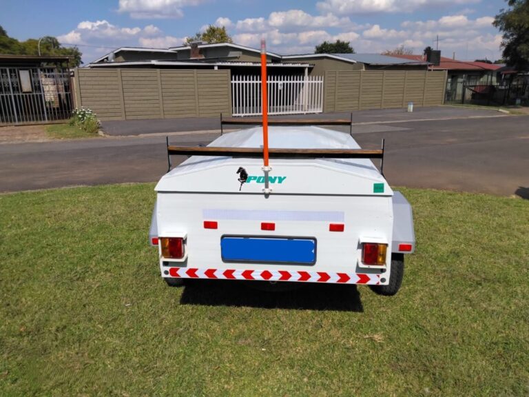 Rear view of white Pony trailer with roof rails